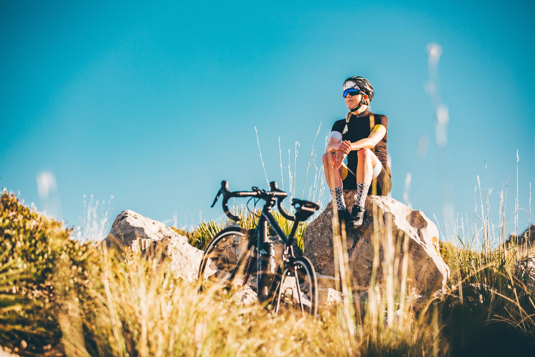 Radfahrerin auf Felsen sitzend