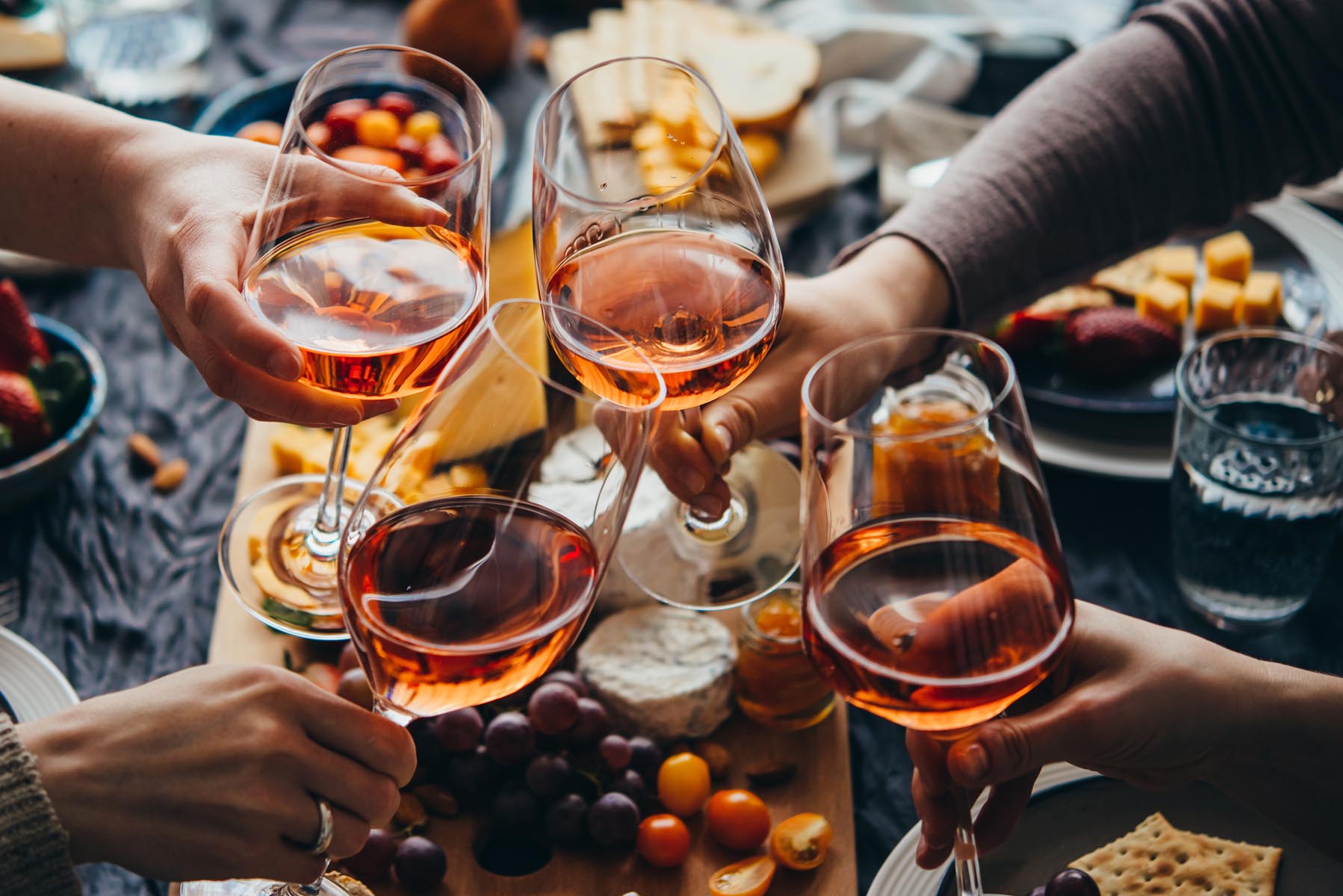 Weingläser mit Rosé beim Anstoßen